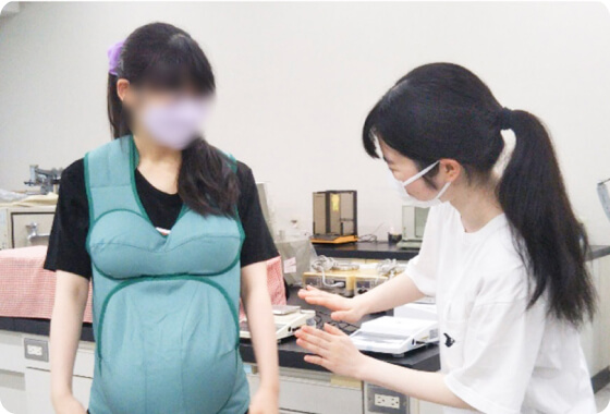 妊婦さんの体型（お腹の重さや胸の形）を再現できるキットで、歩く、椅子に座る、物を拾う等の行動を体験します。